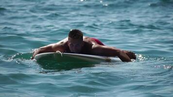 Man Sup Sea. Strong athletic man learns to paddle sup standing on board in open sea ocean on sunny day. Summer holiday vacation and travel concept. Aerial view. Slow motion video