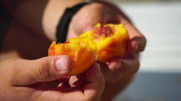 Man eating peach. Bearded man in sunglases eating peach on the beach. Happy man is smiling and resting at sea. Bearded guy enjoying fruits on summer vacation. Vegetarian and healthy lifestyle concept. video