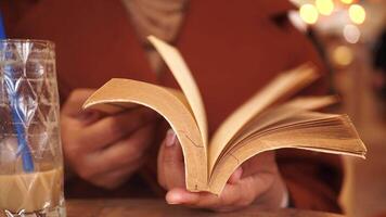 Experience a woman reading in a cozy cafe, embraced by the warmth of autumn vibes video