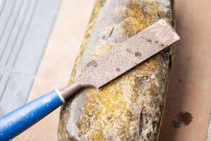 Rusty chisel on weathered sharpening stone photo