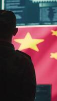 Vertical Chinese military personnel in a high tech government hacking room work on stealing state secrets from rival countries in hybrid war. Chinese army exploit advanced technology, inflict fear. Camera A. video