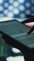 Vertical Cybersecurity expert in a governmental IT environment with the American flag. Monitoring cybersecurity, encryption and data security on a tablet to protect against cyber threats. Close up. Camera A. video