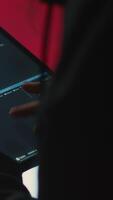Vertical Chinese hacker uses a tablet in governmental cyber operations office to work on hybrid warfare and political manipulation. Inflicting manipulation and propaganda for the communism ideology. Camera A. video