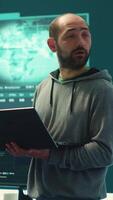 Vertical Governmental hackers breaching network security with advanced techniques, cyber defense in action. Team of IT experts working on gaining access to collect information, big screen. Camera A. video