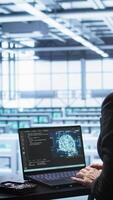 Vertical Engineer in data center using artificial intelligence computing simulating human brain thought processes in computerized model. Employee works on laptop with AI machine learning algorithms, camera B video