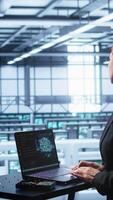 Vertical Computer scientist in data center using artificial intelligence computing simulating human brain. IT professional working on notebook with AI machine learning algorithms, camera B video