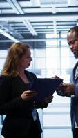 Vertical Team of admin in server hub check recovery plan, monitoring data center energy consumption across components. Coworkers ensures sensors are functioning optimally, doing routine disk checks, camera B video