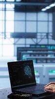 Vertical Engineer in data center using artificial intelligence computing simulating human brain thought processes in computerized model. Employee works on laptop with AI machine learning algorithms, camera A video