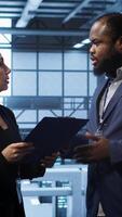 Vertical Team of admin in server hub check recovery plan, monitoring data center energy consumption across components. Coworkers ensures sensors are functioning optimally, doing routine disk checks, camera A video