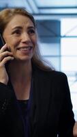 Vertical Technician in data center talking in phone call, doing yearly inspection. On field system administrator talking with manager in server hub during telephone call, monitoring servers, camera A video