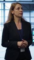 Vertical Admin walking in data center, monitoring systems to identify root cause of errors. IT specialist in server farm establishment doing diagnosis, looking for equipment bugs in need of repairing, camera A video