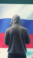 Vertical A Russian hacker working in a governmental hacking room with the Russian flag on big screen. Inflicting cyber terror, propaganda, fake news and misinformation in hybrid warfare. Camera B. video