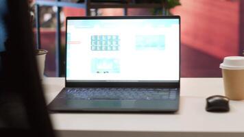 Empty home office with a laptop showing financial data sales reports, setup of a small business owner working remotely. Finance and economy infographics balance. Money management. video