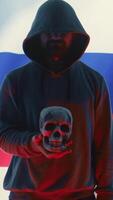Vertical Russian hackers creating dark web maniac cybercrime in a control room, sinister man holding a skull hinting at death threats. Aggressive harmful criminal activity, cyber terrorism. Camera B. video