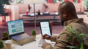 Financial manager taking notes for a new funding strategy, calculating profit and expenses at home desk. Working to increase business profit, accounting specialist evaluating market trends. Camera A. video