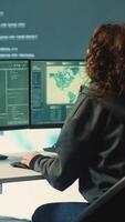 Vertical Group of governmental hackers using hacking tools to secure a network, focusing on cyber defense and data protection measures. Experts team examining important information on big screen. Camera A. video