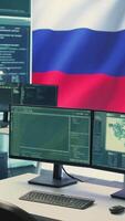 Vertical Surveillance and hacking room with a Russian flag on big screen, representing cyber espionage and digital manipulation. Russian government works on propaganda and misinformation campaigns. Camera B. video