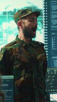 Vertical Military IT experts conducting surveillance and espionage activities using advanced technology and big screen. Governmental agency protecting against cyber threats and digital mercenaries. Camera A. video