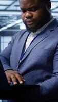 Vertical Software developer in data center runs diagnostic tests and error checking utilities on laptop to fix problems. IT expert looking for network issues affecting rigs performance using notebook, camera B video