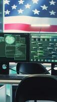 Vertical Empty digital operations room with an american flag running on big screen, emphasizing network security and cyber safety. Advanced technology and hacking tools for national security. Camera A. video