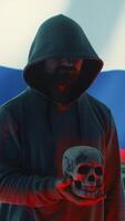 Vertical Russian hackers creating dark web maniac cybercrime in a control room, sinister man holding a skull hinting at death threats. Aggressive harmful criminal activity, cyber terrorism. Camera A. video