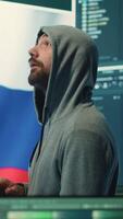Vertical Russian cyber forces operative working with computer systems in a governmental hacking room. Inflicting cyberterrorism, fake news and dangerous brainwashing, digital mercenary activities. Camera A. video