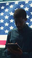 Vertical Cybersecurity expert working in a governmental hacking room with the American flag shown on big screen. Safeguarding data protection and doing cyber threat analysis in a high tech office. Camera A. video