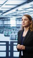Vertical System administrator in high tech data center looking at hologram visualization. Computer scientist working on securing server terminals using AR tech, preventing hacker attacks, camera B video