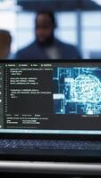 Vertical Focus on notebook used by engineers in server hub in blurry background using artificial intelligence computerized model. Close up of laptop with AI deep learning using pattern recognition, camera A video