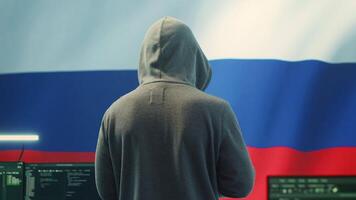 A Russian hacker working in a governmental hacking room with the Russian flag on big screen. Inflicting cyber terror, propaganda, fake news and misinformation in hybrid warfare. Camera A. video