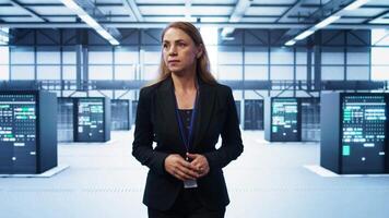 Manager inspecting server room gear, walking between mainframes. Woman doing evaluation of data center workspace, checking infrastructure, monitoring performance, camera B video