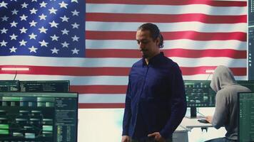 An American hacker in a governmental cyber defense room, showcasing advanced technology and hacking tools. Working on cybersecurity monitoring, digital security and national security. Camera B. video