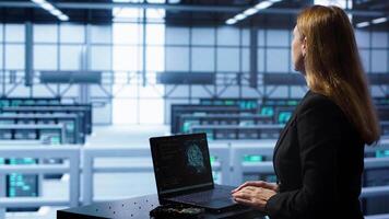Engineer in data center using artificial intelligence computing simulating human brain thought processes in computerized model. Employee works on laptop with AI machine learning algorithms, camera A video