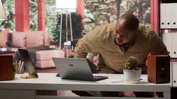 Home based entrepreneur using laptop for online trading and project management, ensuring successful remote work environment. Focusing on financial analysis in telecommuting setup. Camera A. video
