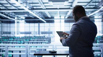 System administrator in server room establishment installing newly ordered storage unit. Software developer working in data center facility housing storage rackmounts, camera B video