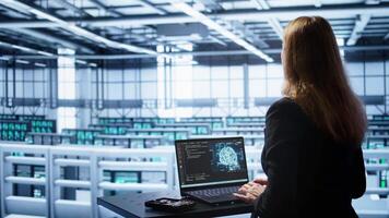 Engineer in data center using artificial intelligence computing simulating human brain thought processes in computerized model. Employee works on laptop with AI machine learning algorithms, camera B video