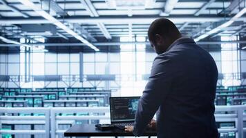 Artificial intelligence technology simulating human brain used by engineer in data center. Worker working on digital device with AI tech machine learning algorithms, camera B video