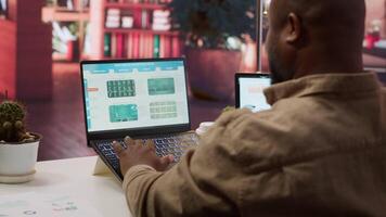 Entrepreneur calculating expenses with online invoices on laptop, creating an analytics reports plan for investment strategy. Working on increasing budget for business expansion. Camera A. video