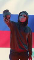 Vertical Russian cyber criminal with anonymous mask and hood holding a skull, making death threats and asking for ransom. Dangerous evil person symbolizing cyber threats and cyberterrorism. Camera B. video