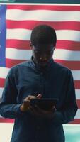 Vertical Cybersecurity expert working in a governmental hacking room with the American flag shown on big screen. Safeguarding data protection and doing cyber threat analysis in a high tech office. Camera B. video