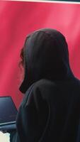 Vertical Chinese hacker working in governmental hacking room with Chinese flag on a big screen. Having the mission on inflicting fear and misinformation among the population. Dictatorship propaganda. Camera B. video