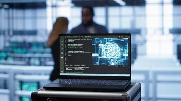 Focus on notebook used by engineers in server hub in blurry background using artificial intelligence computerized model. Close up of laptop with AI deep learning using pattern recognition, camera A video