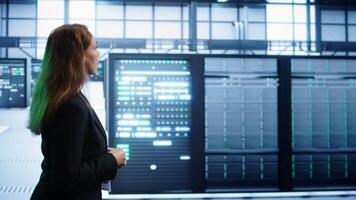 Engineer inspecting server room hardware, walking between supercomputers. IT professional supervising data center workplace, checking equipment, monitoring performance, camera B video
