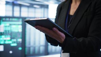 ordinateur scientifique gérant Les données centre avec Avancée La technologie en utilisant numérique appareil. proche en haut coup de la personne dans serveur pièce optimiser Les données centre équipement avec tablette, caméra b video