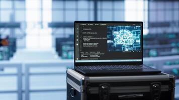 Laptop in data center facility with artificial intelligence computing simulating human brain, handheld camera shot. Close up of device displaying AI machine learning algorithms in server hub, camera A video