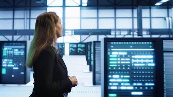 Engineer inspecting server room hardware, walking between supercomputers. IT professional supervising data center workplace, checking equipment, monitoring performance, camera A video