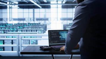 Engineer in server hub works with artificial intelligence computerized model simulating human brain. Man working on laptop with AI machine learning algorithms using pattern recognition, camera B video