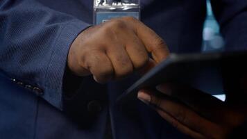 Technician in server hub checking recovery plan on tablet, monitoring energy consumption across mainframes. Close up shot of man in data center making sure rigs are functioning optimally, camera A video