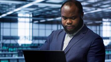 Software developer in data center runs diagnostic tests and error checking utilities on laptop to fix problems. IT expert looking for network issues affecting rigs performance using notebook, camera A video