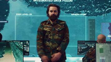 Sergeant presenting his salute with respect for the colonel and high ranking military officers, saluting the captains while he works on intelligence in command center, pride and duty. Camera A. video